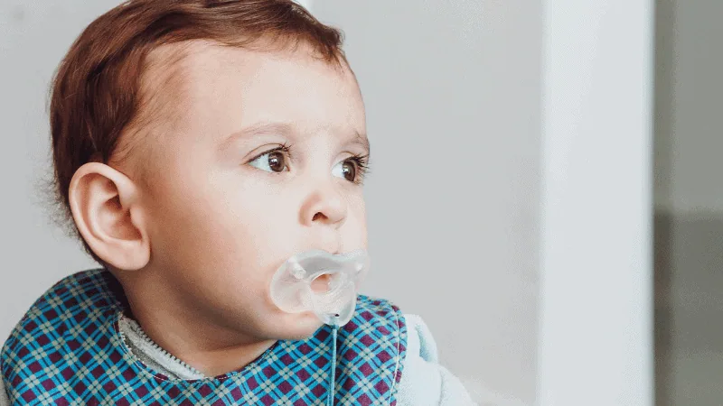  A baby is using a rubber pacifier