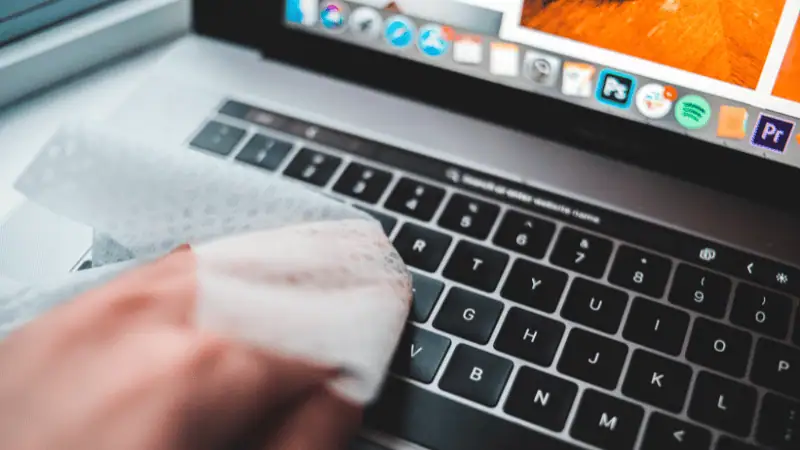 This picture shows the process of a person cleaning the keyboard