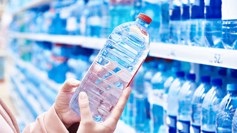 A woman is holding a plastic bottle.