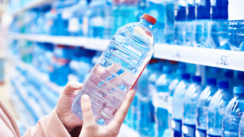 A woman is holding a plastic bottle.